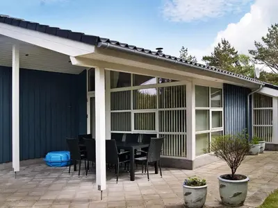 a screened in patio with a table and chairs at 10 person holiday home in Fjerritslev-By Traum in Torup Strand