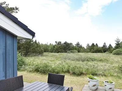 a patio with a table and chairs and a field at 10 person holiday home in Fjerritslev-By Traum in Torup Strand
