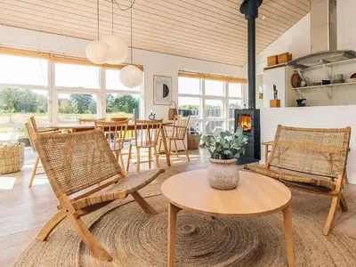 a living room with chairs and a table and a dining room at 6 person holiday home in Øster Assels-By Traum in Sillerslev