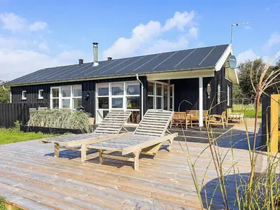 a group of chairs sitting on a deck in front of a house at 6 person holiday home in Øster Assels-By Traum in Sillerslev