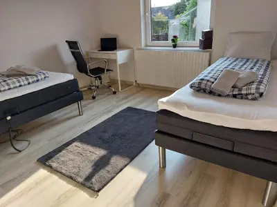 a bedroom with two beds and a desk and a chair at Venos Home in Lemvig