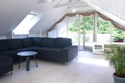 a living room with a couch and a table at Dejligt og stort hus med spa og sauna in Roslev