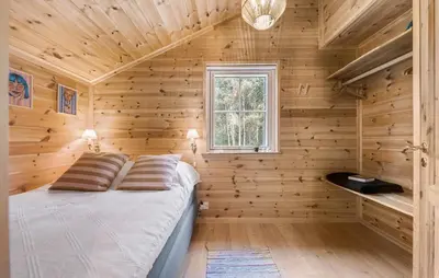 a bedroom with wooden walls and a bed in a room at 3 Bedroom Gorgeous Home In Skals in Skals