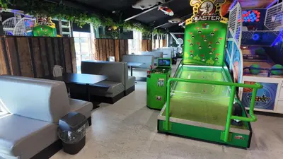 a gaming room with a green arcade game at Stort sommerhus - Legeland for store og små in Pandrup