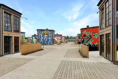 a street with paintings on the sides of buildings at Funart 3 in Pandrup