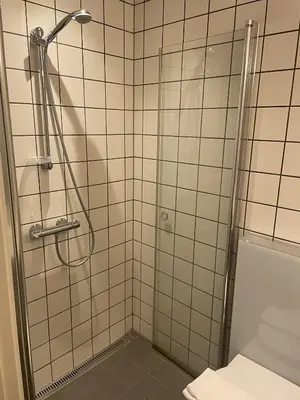 a shower with a glass door in a bathroom at Hotel Tante in Lemvig
