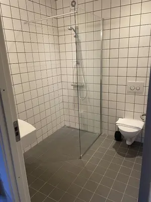 a bathroom with a shower and a toilet at Hotel Tante in Lemvig