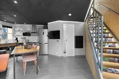 a kitchen and dining room with a table and a staircase at Funart 7 in Pandrup