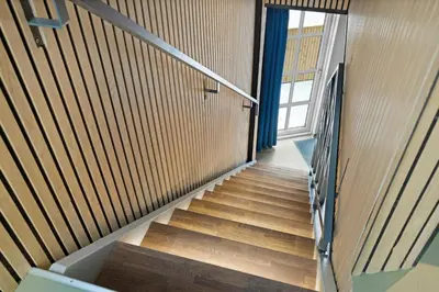 a staircase in a building with wooden walls and a window at Funart 7 in Pandrup