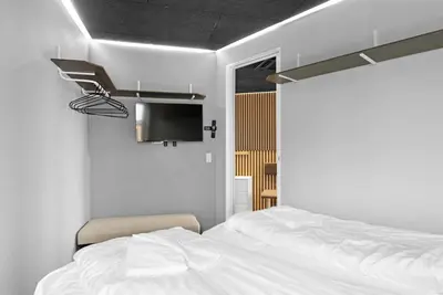 a bedroom with a white bed and a tv at Funart 15 in Pandrup