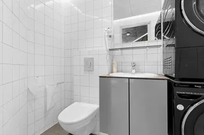 a white bathroom with a toilet and a sink at Funart 15 in Pandrup