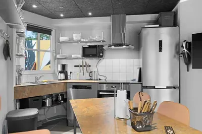 a kitchen with a stainless steel refrigerator and a table at Funart 14 in Pandrup