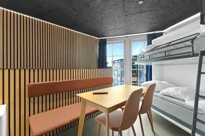 a bedroom with a table and chairs and a bunk bed at Funart 11 in Pandrup