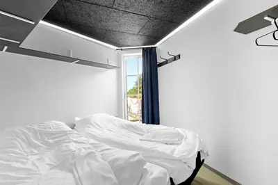 a white bed in a room with a window at Funart 12 in Pandrup