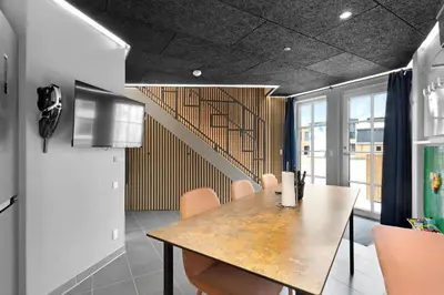 a dining room with a table and a staircase at Funart 12 in Pandrup
