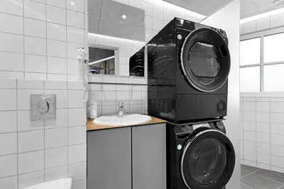 a bathroom with a washing machine and a sink at Funart 5 in Pandrup