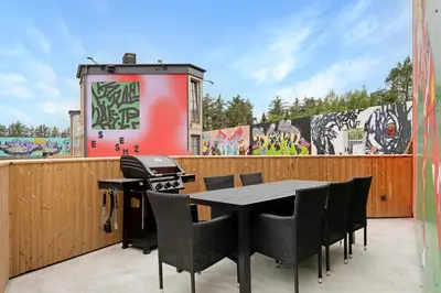 a patio with a table and chairs and a grill at Funart 5 in Pandrup