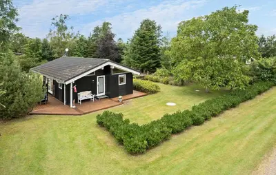 a black cabin with a deck in a yard at 2 Bedroom Cozy Home In Højslev in Højslev