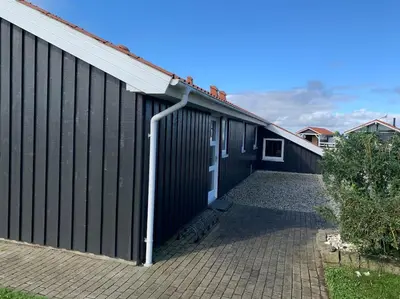 a black building with a white door and a driveway at 4 bedrooms and a beautiful view in Vinderup