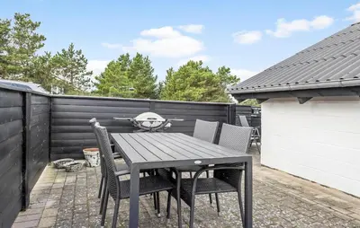 a wooden table and chairs on a patio at 2 Bedroom Amazing Home In Thisted in Thisted