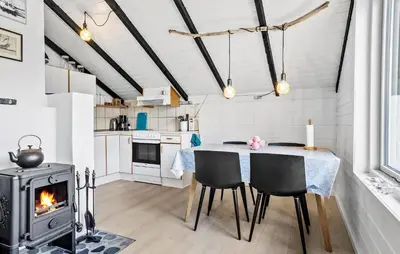 a kitchen and dining room with a table and a stove at 2 Bedroom Amazing Home In Thisted in Thisted