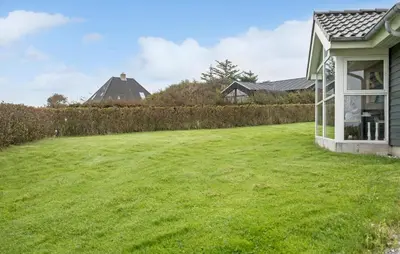 a large grassy yard next to a house at Cozy Home In Lemvig With Sauna in Lemvig