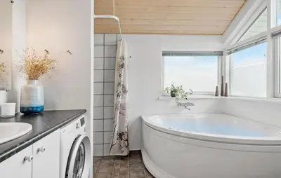 a white bathroom with a tub and a window at Cozy Home In Lemvig With Sauna in Lemvig