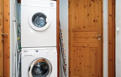 a washer and dryer next to a door at Holiday Home Blokhus With Sauna 156 in Blokhus