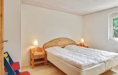 a bedroom with a large bed in a room at Holiday Home Blokhus With Sauna 156 in Blokhus