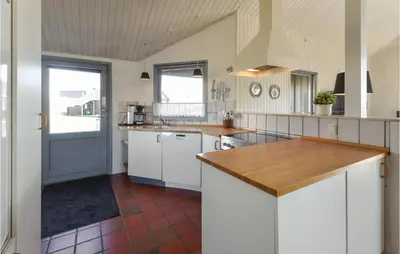 a kitchen with white cabinets and a wooden counter top at Holiday Home Vestervig With A Fireplace 164 in Vestervig