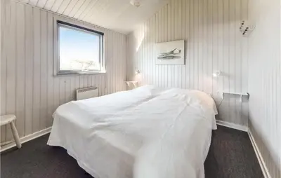 a white bedroom with a white bed and a window at Holiday Home Vestervig With A Fireplace 164 in Vestervig