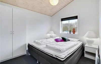 a bedroom with a large bed with a window at 3 Bedroom Amazing Home In Vinderup in Vinderup