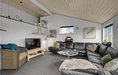 a living room with a leather couch and a tv at 3 Bedroom Amazing Home In Vinderup in Vinderup