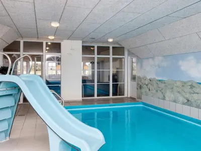 a swimming pool with a slide in a building at Luxury Beach Retreat - By Traum Ferienwohnungen in Harboør