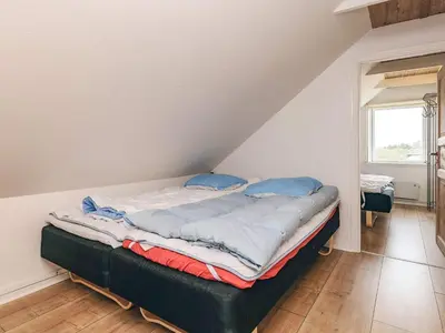 a bed with blue pillows on it in a room at Seaside Escape with Views - By Traum Ferienwohnungen in Vestervig