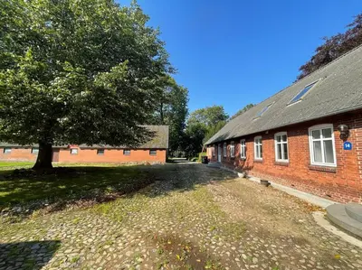 a brick building with a tree in front of it at Wohnung in Salling in Buksager