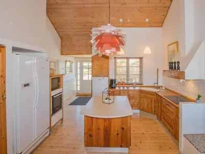 a kitchen with wooden cabinets and a white refrigerator at Luxury Lodge with Limfjord View - By Traum Ferienwohnungen in Spottrup