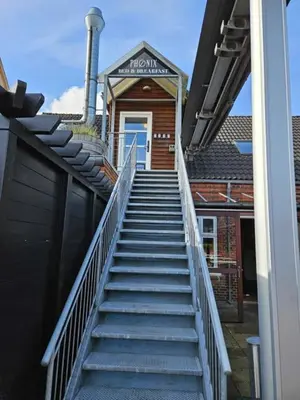 a staircase leading up to a building with a blue door at B&B Phønix in Holstebro
