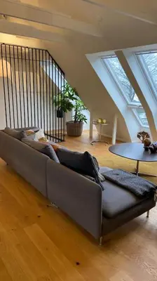 a living room with a couch and a table at Rækkehus tæt på skov, sø og by in Viborg