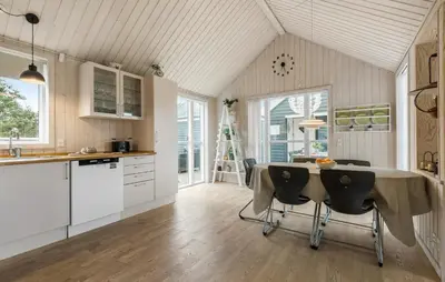 a kitchen with white cabinets and a table with chairs at Beautiful Home In Farsø With Wifi in Farsø