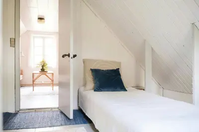 a bed with a blue pillow in a room at Summer House For The Big Family Close To The Fjord in Agger