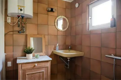 a bathroom with a sink and a mirror at Summer House For The Big Family Close To The Fjord in Agger