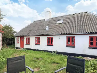 a white house with red windows on a yard at Panoramic View Fisherman's House - By Traum Ferienwohnungen in Vesløs