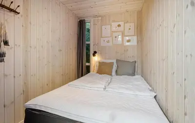 a bed in a room with wood paneling at Pet Friendly Home In Spøttrup With Wifi in Spottrup