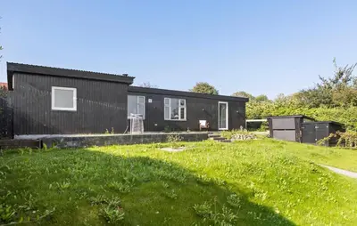 a black house on a hill with a yard at 2 Bedroom Lovely Home In Thisted in Thisted