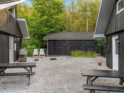 a patio with two picnic tables and a building at Holiday Home Vicente - 14km to the fjord by Interhome in Års