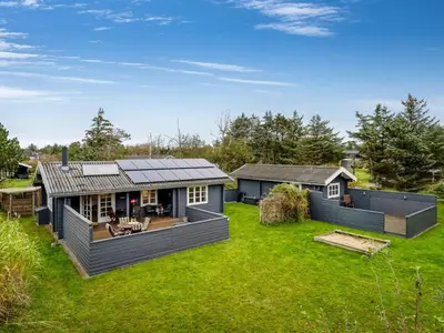 a home with a large yard with a house at Holiday Home Tammo - 1-1km from the sea by Interhome in Blokhus