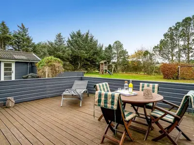 a patio with a table and chairs on a deck at Holiday Home Tammo - 1-1km from the sea by Interhome in Blokhus