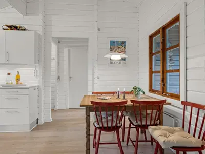 a kitchen with a wooden table and red chairs at Holiday Home Tammo - 1-1km from the sea by Interhome in Blokhus