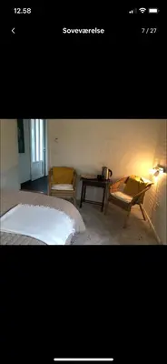 a bedroom with a bed and two chairs and a table at Naturlig Ro in Aalborg